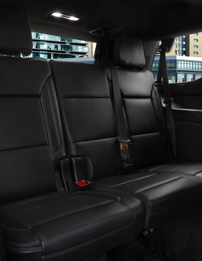 Rear bench and third-row view inside a 6-door GMC Yukon Denali SUV, designed for spacious, high-occupancy transport.