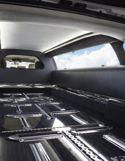 Casket transport area with polished chrome rollers inside a Lincoln Nautilus hearse conversion by Quality Coachworks.
