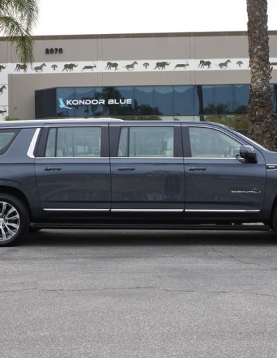 Full side view of a grey 6-door GMC Yukon Denali conversion showing extended body and sleek OEM-style finish.