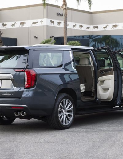 Rear and side doors open on a 6-door Cadillac Escalade SUV, showcasing the extended cabin built by Quality Coachworks.