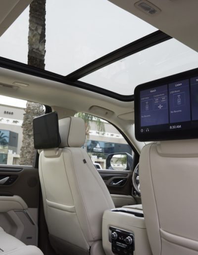 Rear seat entertainment screen and panoramic sunroof inside a 6-door Yukon Denali SUV conversion by Quality Coachworks