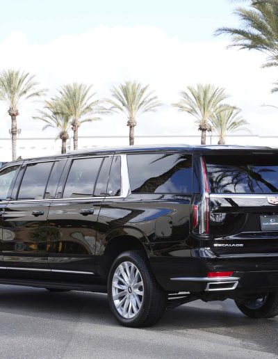 Rear three-quarter driver-side view of a black 6-door GMC Yukon Denali SUV, highlighting extended body styling and privacy tint.
