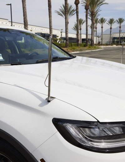 Side view of a white Lincoln Nautilus hearse featuring dual antennas and custom funeral-ready exterior trim.