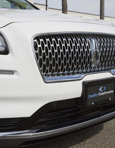 Front grille of a white Lincoln Nautilus hearse conversion with chrome trim, customized for professional funeral use.