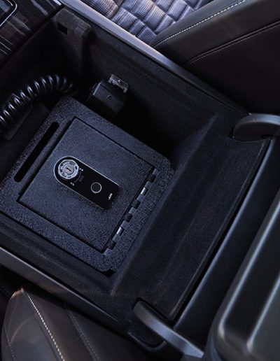 Integrated in-console vehicle safe installed in a custom luxury interior by Quality Coachworks, designed for discreet secure storage.