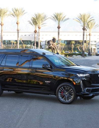 Angled side view of a fully blacked-out Cadillac Escalade custom SUV built for VIP and executive transport.