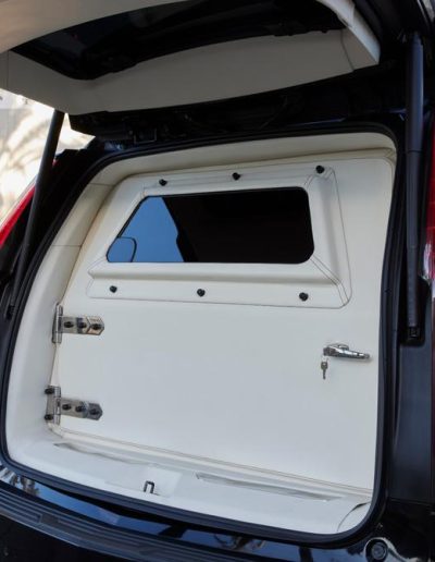 Armored rear door panel of a Cadillac Escalade SUV with privacy window and white finish, custom-built by Quality Coachworks.