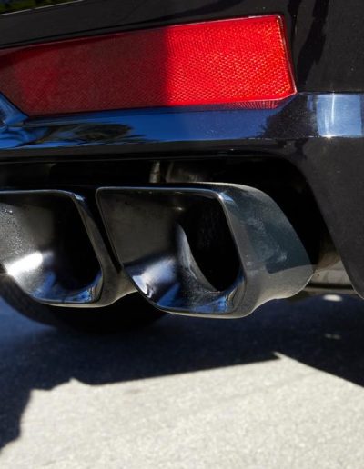 Close-up of custom quad exhaust tips on an armored Cadillac Escalade SUV, built for performance and visual impact by Quality Coachworks.