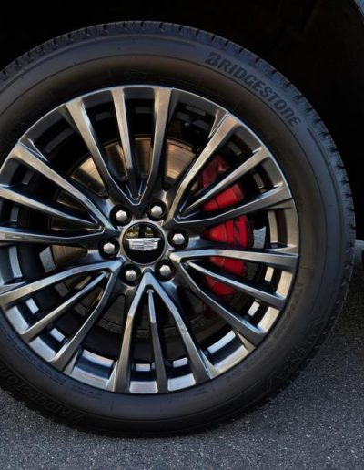 Close-up of custom black alloy wheel with red calipers on a Cadillac Escalade CEO conversion by Quality Coachworks