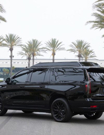 Rear angle of a blacked-out Cadillac Escalade SUV conversion, showcasing the sleek custom exterior built by Quality Coachworks.