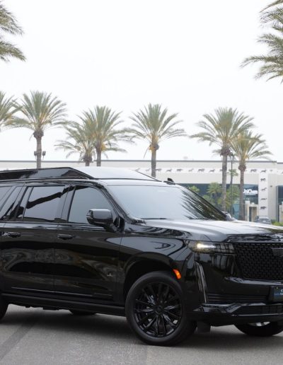 Side profile of a fully blacked-out Cadillac Escalade conversion parked in Southern California, customized by Quality Coachworks.